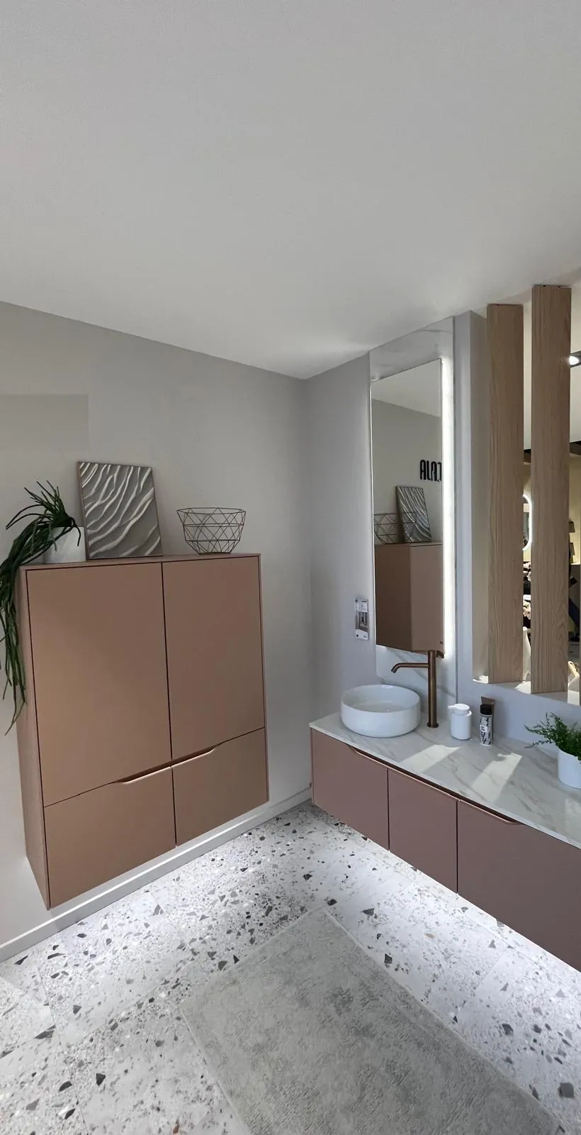 Badmöbel in Altrosa mit Hängeschrank und Holzlamellen in einer Ausstellung