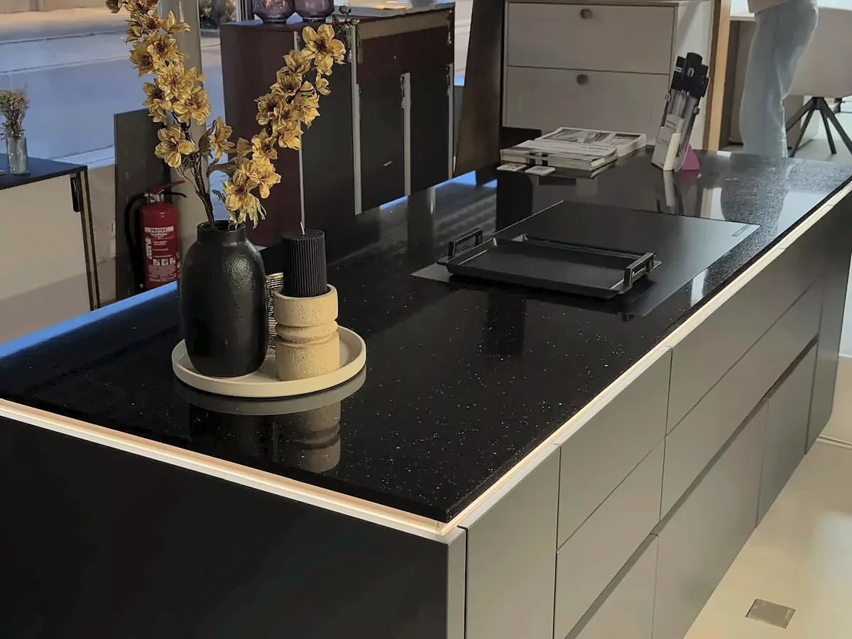 Schwarze Kochinsel mit Kochfeld und LED-Kante in der Ausstellung im Studio Hüfingen